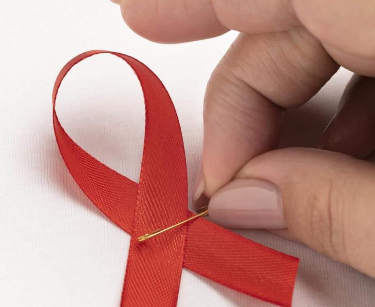 VIH | Anacer, persona sosteniendo una cinta del día mundial del sida